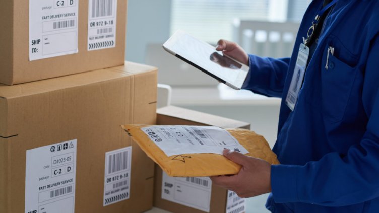 Close-up image of mail worker checking information on parcels; Shutterstock ID 584392576; Departmental Cost Code : 162800; Project Code: GBLMKT; PO Number: GBLMKT; Other: 